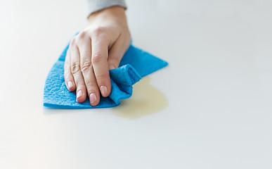 Image showing close up of hand cleaning table surface with cloth