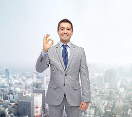 Image showing happy businessman in suit showing ok hand sign