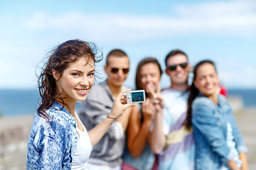 Image showing happy teenagers taking photo outside