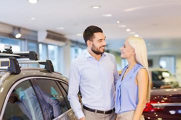 Image showing happy couple buying car in auto show or salon