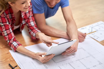 Image showing close up of couple with tablet pc and blueprint