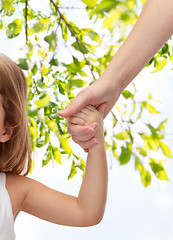 Image showing close up of woman and little girl holding hands