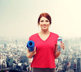 Image showing smiling girl with bottle of water after exercising