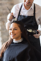 Image showing happy woman with stylist coloring hair at salon