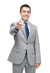 Image showing happy smiling businessman in suit pointing at you