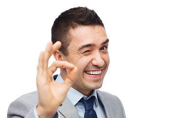 Image showing happy businessman in suit showing ok hand sign