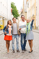 Image showing group of smiling friends with map and photocamera