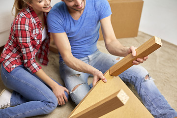 Image showing close up of couple unpacking furniture and moving