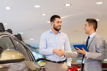 Image showing happy man shaking hands in auto show or salon