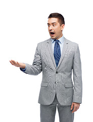 Image showing shocked businessman in suit looking to empty hand