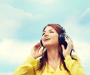 Image showing smiling young girl in headphones at home