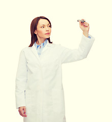 Image showing young female doctor writing something in the air