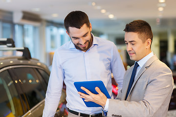 Image showing happy man with car dealer in auto show or salon