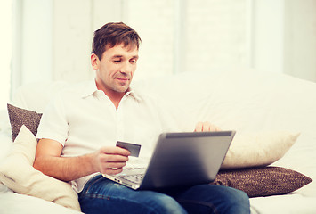 Image showing man with laptop and credit card at home