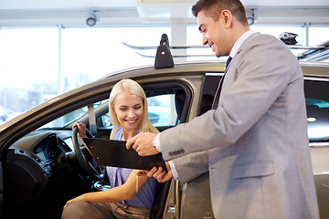 Image showing happy woman with car dealer in auto show or salon