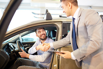 Image showing happy man with car dealer in auto show or salon