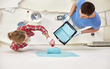 Image showing couple with paint roller painting wall at home