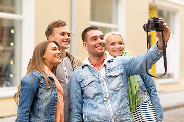 Image showing group of smiling friends making selfie outdoors