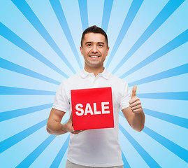 Image showing smiling man with red sale sigh showing thumbs up