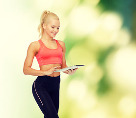 Image showing smiling sporty woman with tablet pc computer