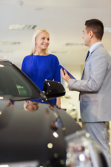 Image showing happy woman with car dealer in auto show or salon