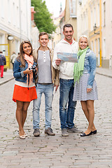 Image showing group of smiling friends with map and photocamera