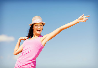 Image showing girl in hat showing direction on the beach