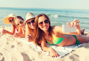 Image showing group of smiling women with smartphone on beach