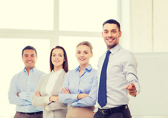 Image showing businessman in office pointing finger at you