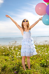 Image showing happy girl waving hands with colorful balloons