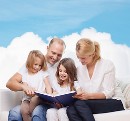 Image showing happy family with book at home