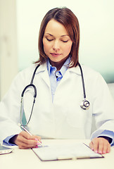 Image showing busy doctor with laptop computer and clipboard