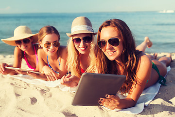 Image showing group of smiling young women with tablets on beach