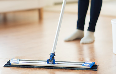 Image showing close up of woman with mop cleaning floor at home