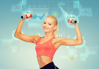 Image showing smiling beautiful sporty woman with dumbbells