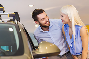 Image showing happy couple buying car in auto show or salon