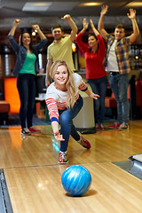 Image showing happy young woman throwing ball in bowling club