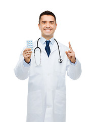 Image showing smiling male doctor in white coat with tablets