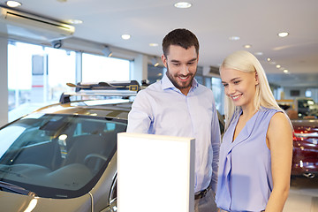 Image showing happy couple buying car in auto show or salon