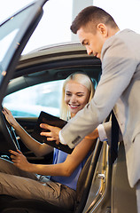 Image showing happy woman with car dealer in auto show or salon