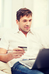 Image showing man with laptop and credit card at home