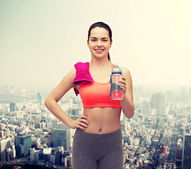 Image showing sporty woman with towel and water bottle