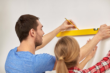 Image showing close up of couple with level measuring wall