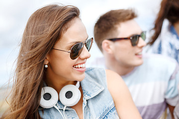 Image showing smiling teenage girl outdoors with friends