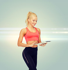 Image showing smiling sporty woman with tablet pc computer