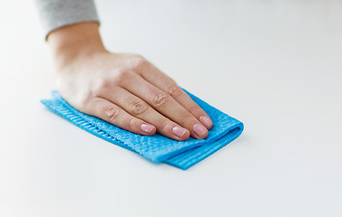 Image showing close up of hand cleaning table surface with cloth