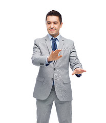 Image showing happy businessman in suit touching something