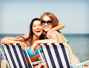 Image showing girls sunbathing on the beach chairs