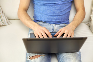 Image showing close up of man typing with laptop at home