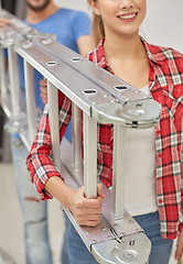 Image showing close up of couple carrying ladder together